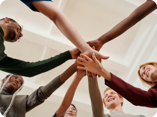 Colleagues joining hands in a team huddle